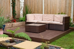 a garden sofa and stool on top of a brown composite deck kit