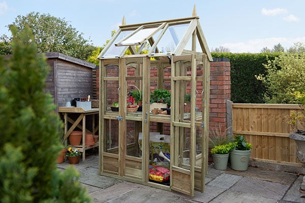 a small wooden greenhouse with multiple doors and an automatic vent
