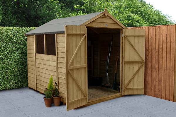 Wooden double door shed with doors open sitting on a grey patio with fencing and trees behind