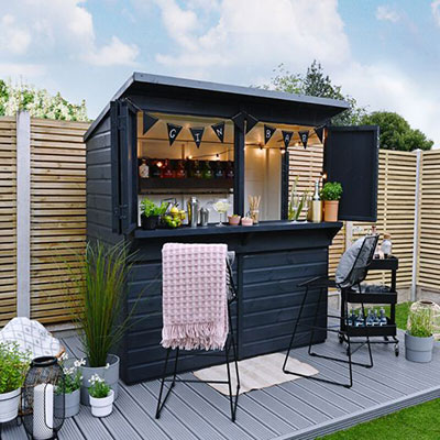 a garden bar painted black and styled as a gin palace