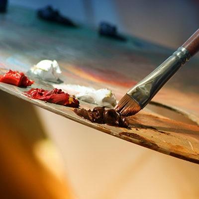 a paintbrush, easel and selection of paints