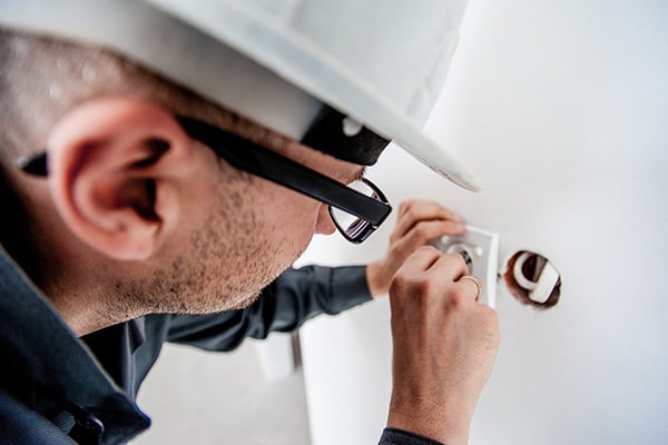An electrician working on a fusebox