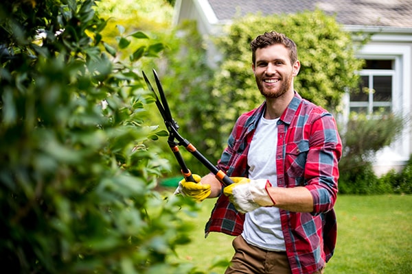man holding hedge shears and smiling