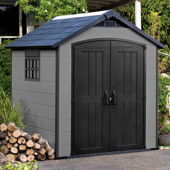 A white and grey wood-effect plastic shed with windowed double doors in a garden setting
