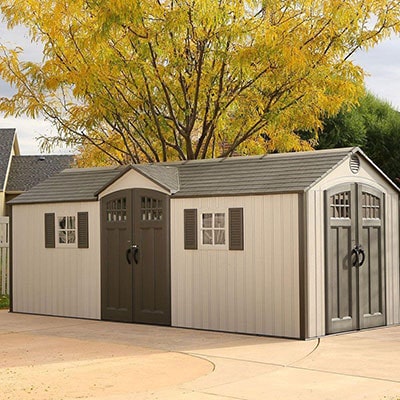 large plastic shed in shades of grey with window shutters and windowed doors