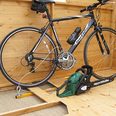 a bicycle in a shed secured by an underfloor locking kit