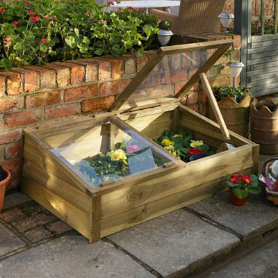 a wooden cold frame with one lid propped open