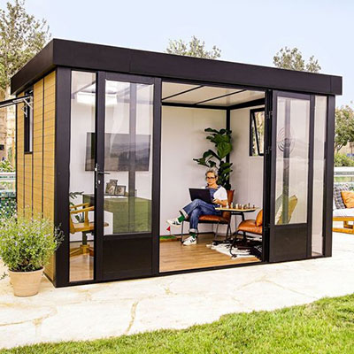 a woman working inside a high-specification Palram Canopia garden office