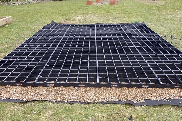 A plastic greenhouse base on a lawn
