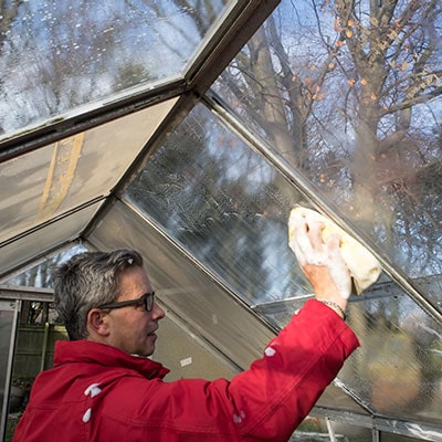 a man cleaning a greenhouse