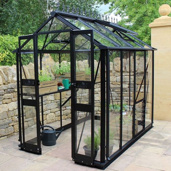 A greenhouse with a black frame and sliding double doors