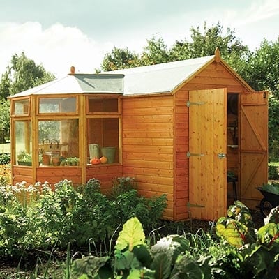 a potting shed surrounded by greenery