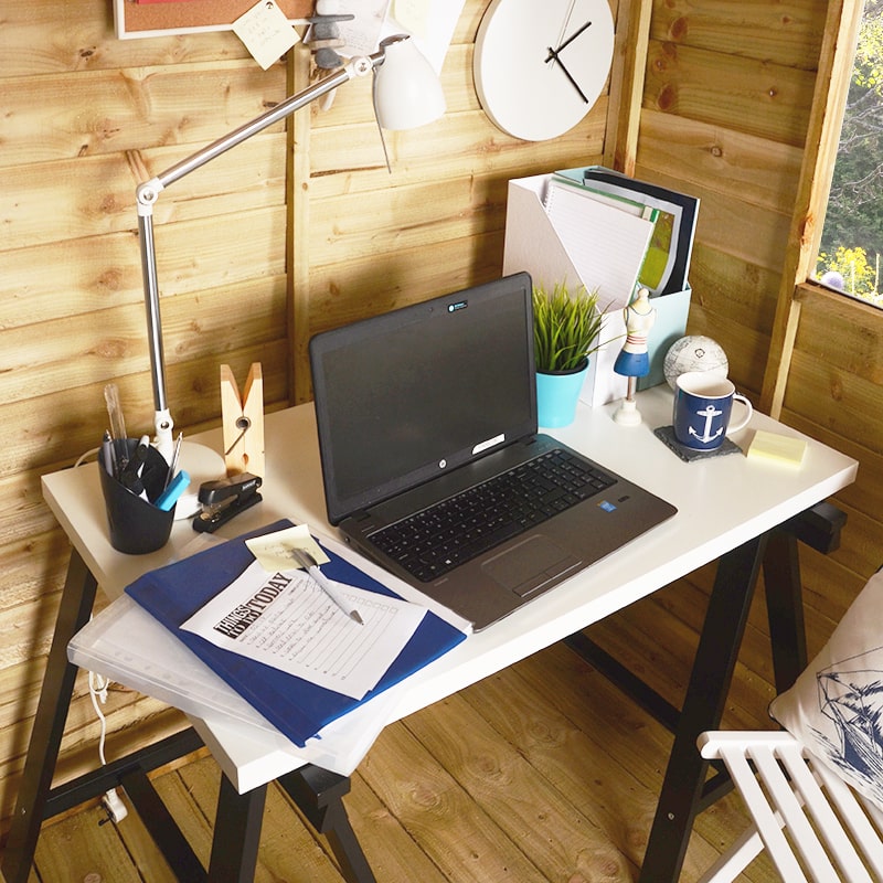 laptop on desk by shed window