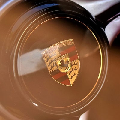 the Porsche badge on a steering wheel