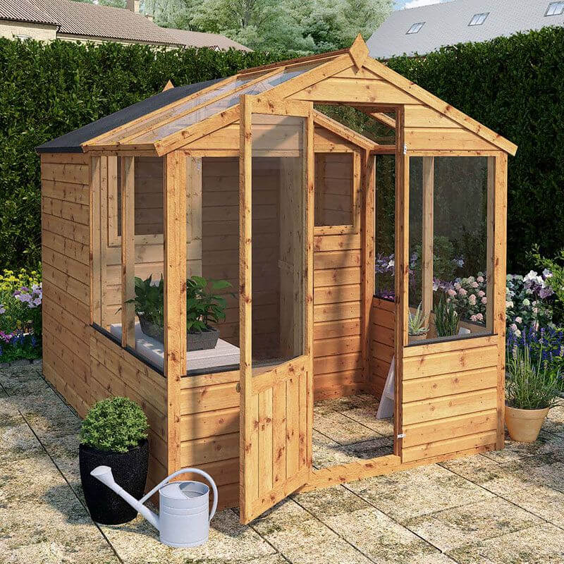 A wooden shed with attached greenhouse