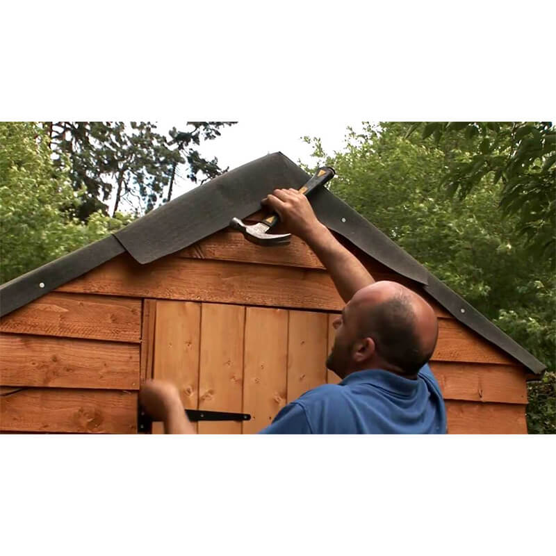 Photo of a Man Fixing a Shed Roof
