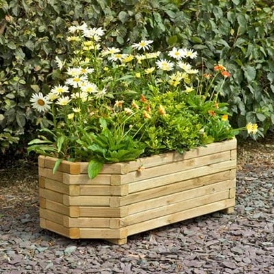 a wooden planter with horizontal slats, full of flowers