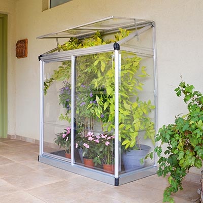 a mini lean-to greenhouse, full of plants, with its roof vent open