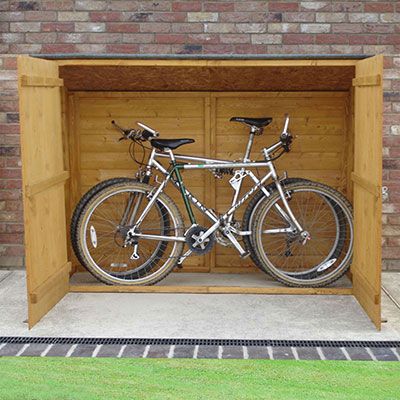 a wooden bike shed, with its double doors open to reveal 2 bikes