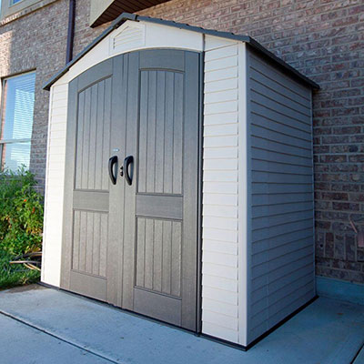 A 7x4.5 taupe and brown plastic shed