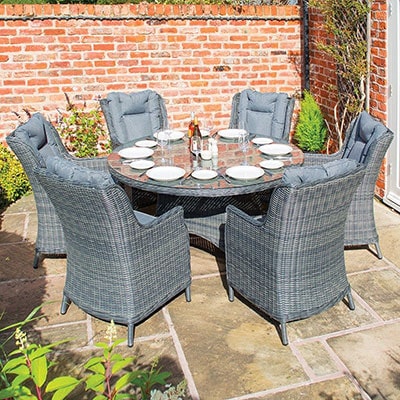 6 grey rattan chairs and a glass top outdoor dining table
