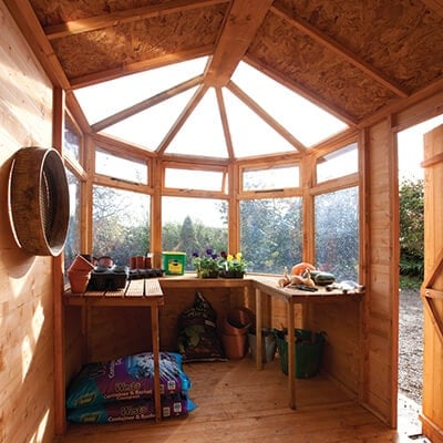 the inside of a potting shed, including potting benches and plants