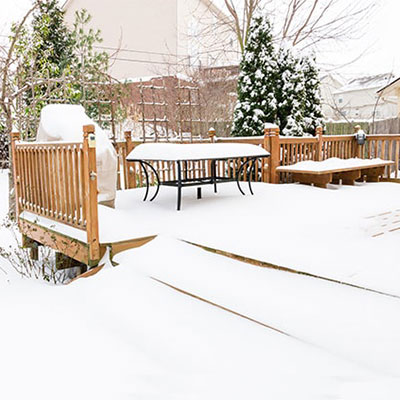 outdoor furniture on garden decking, all covered in snow